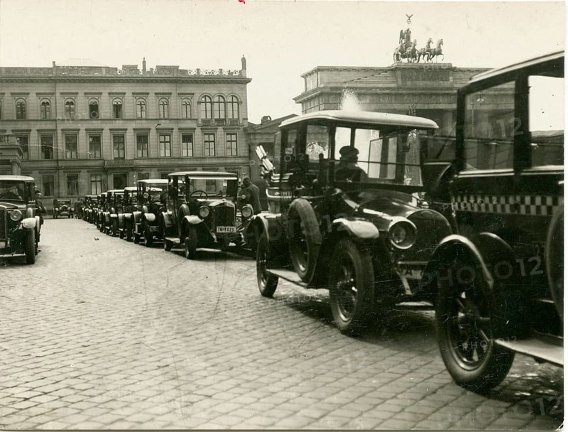 Berlin, Mitte, Pariser Platz, taxi stand, Brandenburg Gate, twenties, A series of vehicles on a paved street in an urban area, historic buildings visible, Sasha Stone, around 1928