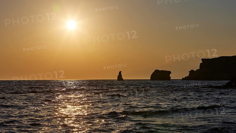 The sun reflects on the calm sea with silhouette-like rocks in the distance, sunset, south of the Amari Basin, Central Crete, Triopetra, rocks in the sea, Crete, Greek Islands, Greece