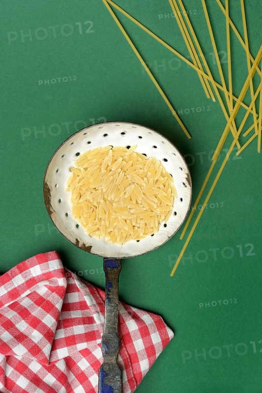 Semi di orzo in sieve ladle, pasta variety in the form of cereal grains and spaghetti