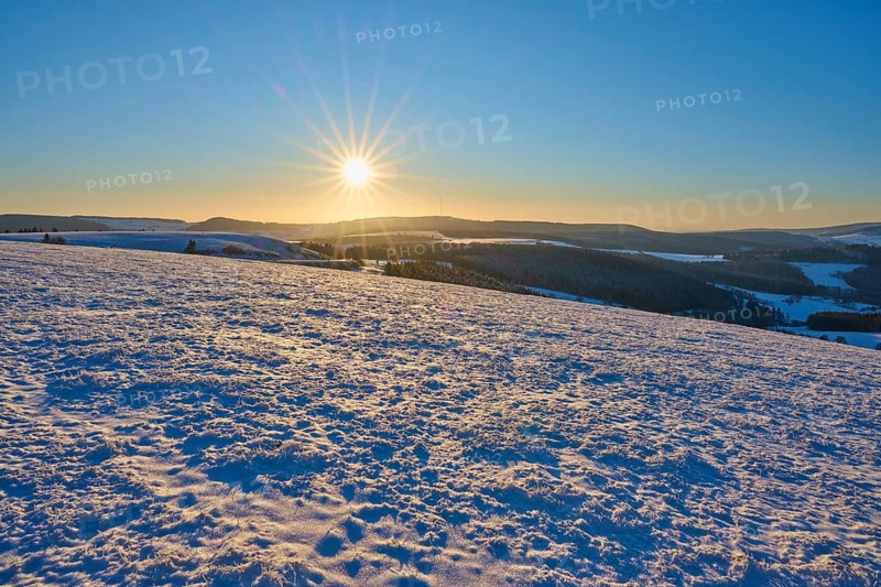 Winter landscape with snow-covered hills and bright sun on the horizon, Winter, Wasserkuppe, Gersfeld, Rhön, Hesse, Germany