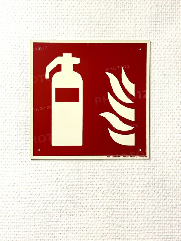 Information sign on with stylized fire extinguisher and flame on wall, Germany
