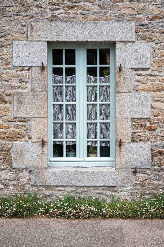 Classic French lattice window with light blue shutters in rustic country style, Roscoff, Finistère, Brittany, France
