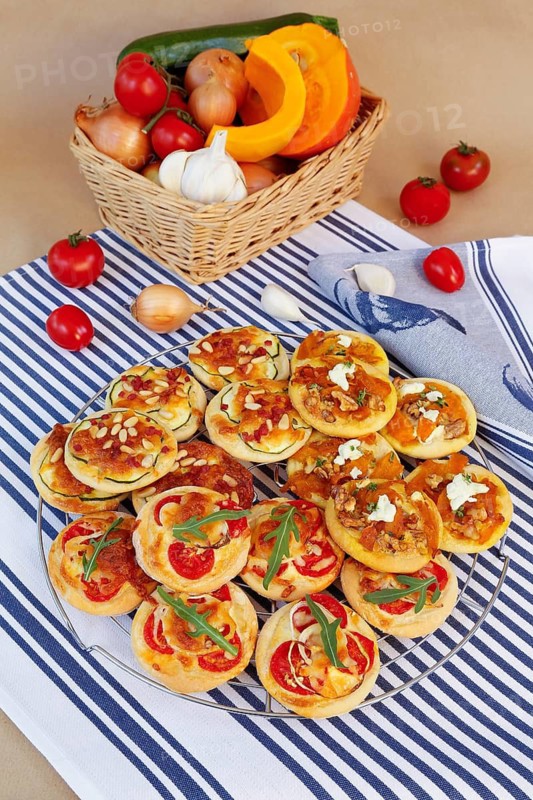 Swabian cuisine, Mini-Dinnete, also Dennete, Dinnede, Dennetle, hearty, salty, yeast pastry topped with vegetables, tomatoes, pumpkin, courgette slices, sour cream, grated cheese, pine nuts, healthy, yeast yeast dough, vegetarian, bake, out of the oven, typical Swabian reinterpreted, party pastry, finger food, appetisers for on the go, back basket with vegetables, onions, garlic, tomatoes, pumpkin, traditional cuisine, food photography, studio, Germany