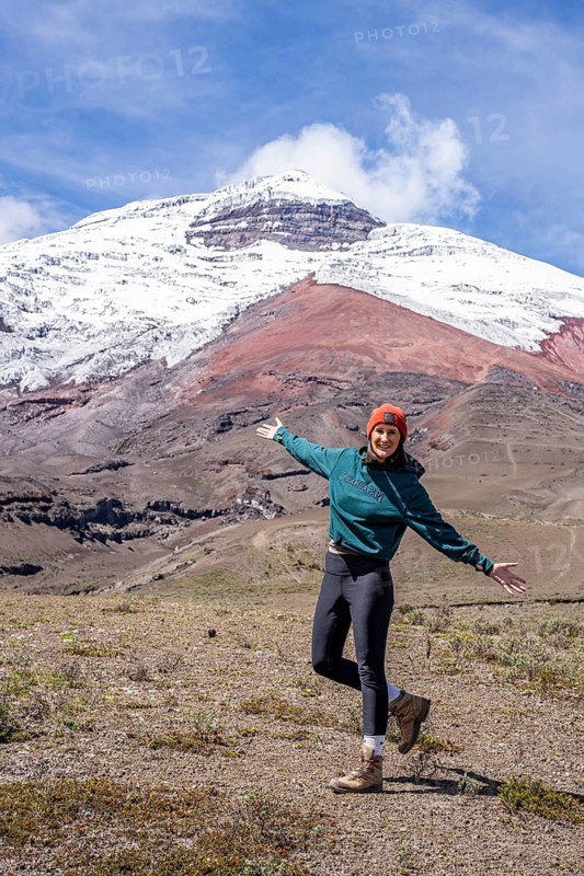 Women poses in front of the Cotopaxi volcano, Cotopaxi, Cotopaxi National Park, Latacunga, Ecuador