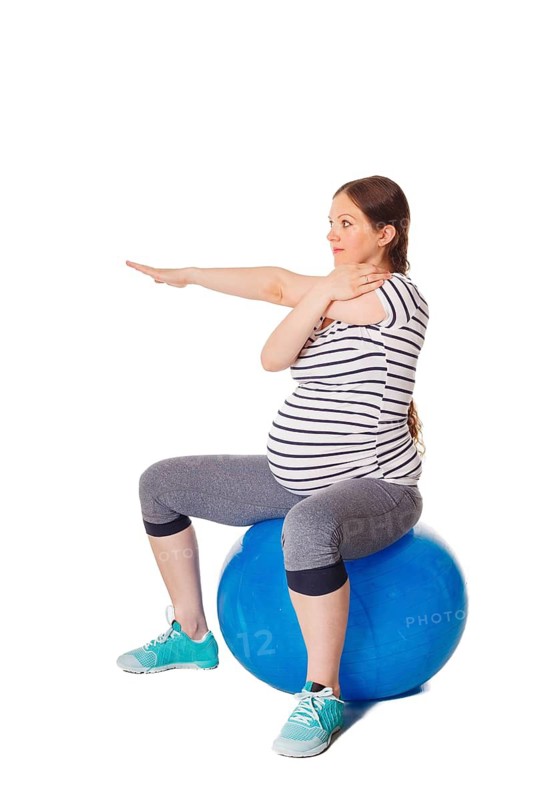 Pregnancy exercise concept, pregnant woman doing stretching exercises with exercise ball isolated on white background