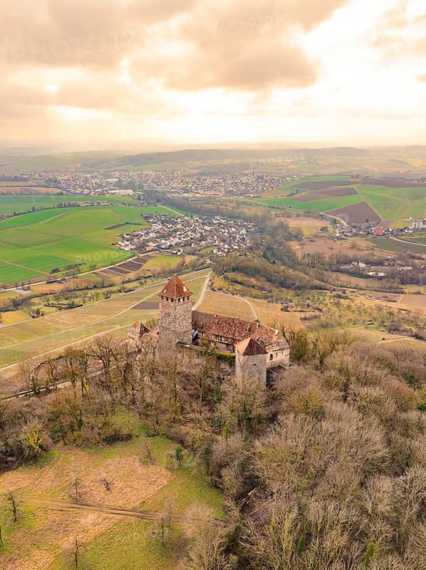 Historic castle on a wooded hill overlooking extensive fields and a town, Lichtenberg Castle, Oberstenfeld, Germany