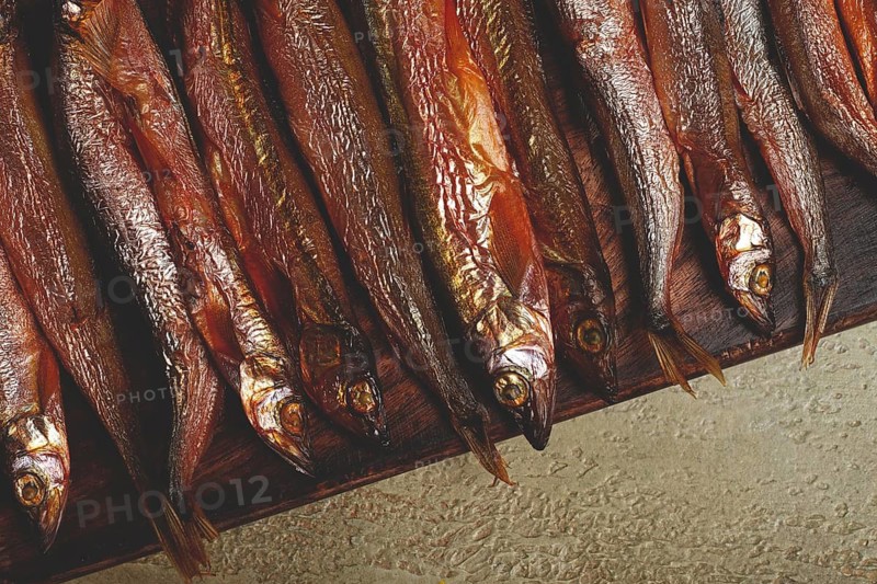 Cold smoked capelin, on a wooden chopping board, no people