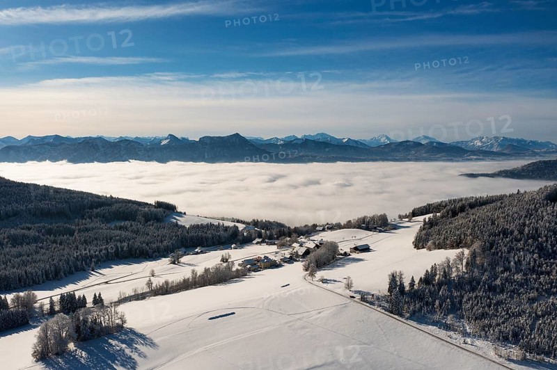 Drone flight over a winter landscape with farmhouses and sea of fog, Mondseeland, Salzkammergut, Upper Austria, Austria