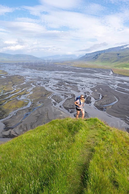 Hiker, Young woman on a hill, view over alluvial land, meandering river, Dímonarhellir, Suðurland, Iceland