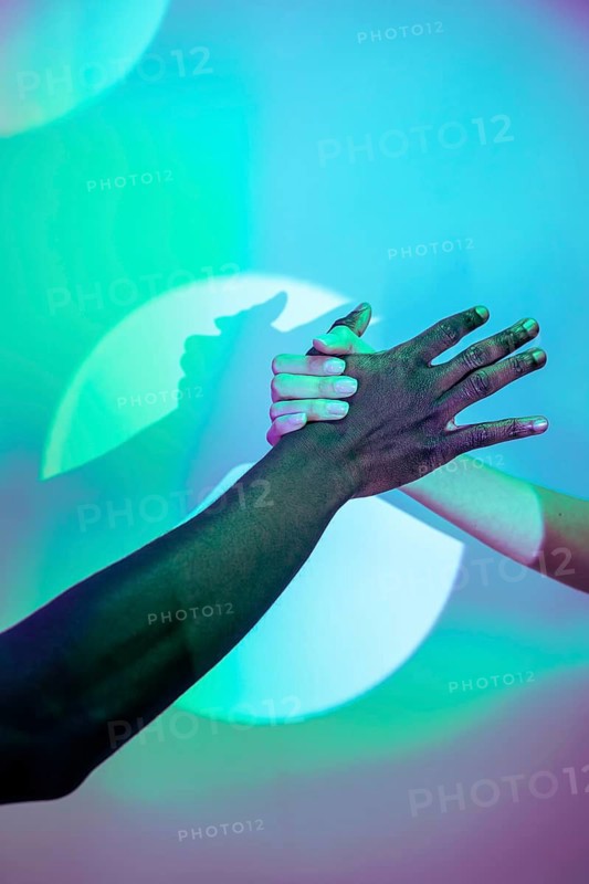 A vibrant image showcasing multiethnic hands clasped together, symbolizing unity and diversity. The colorful background emphasizes harmony and cultural connection