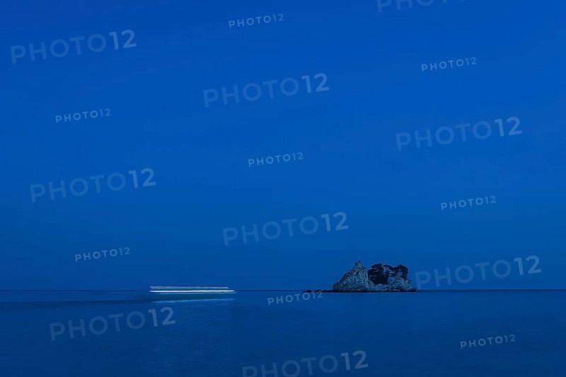 Blurry boat lights flowing by night to the island Sveta Nedjelja in Montenegro.