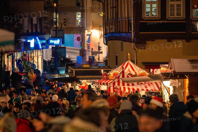 Festive night market with a crowd and illuminated market stalls in the town, Christmas market Calw, Black Forest, Germany