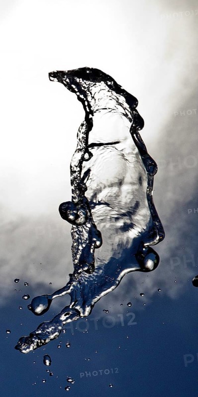 Water frozen as a result of short exposure moving in the backlight in front of the sky