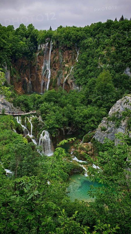 Waterfall in the middle of a wooded gorge with clear lakes, Plitvice Lakes National Park, Croatia