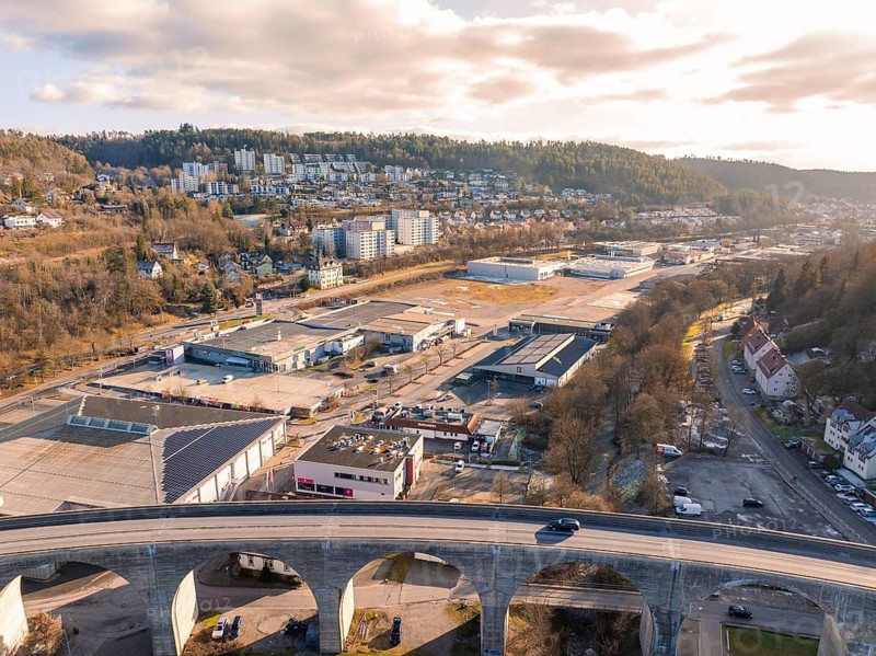 Industrial area and viaduct in front of wooded hills and cloudy sky, Nagold, Black Forest, Germany