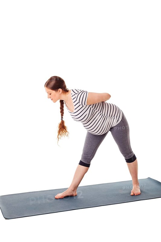 Pregnancy yoga exercise, pregnant woman doing yoga asana parsvottanasana Intense Side Stretch pose isolated on white background