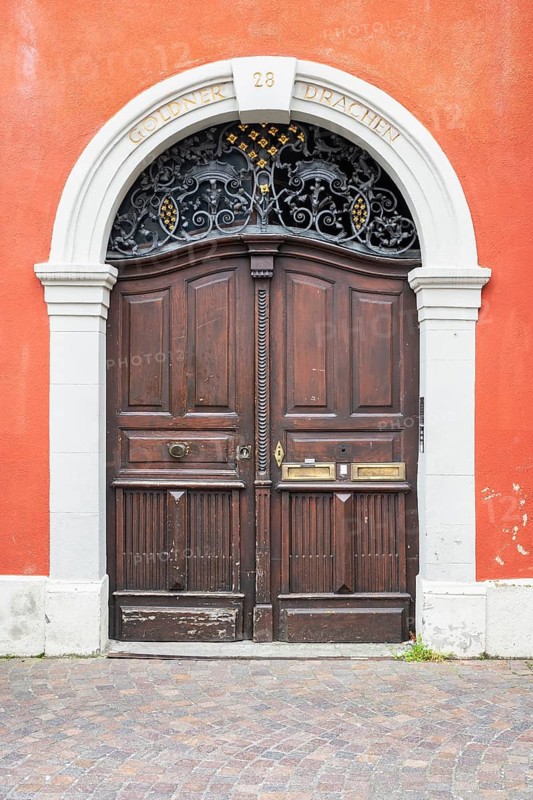 Classic wooden door with decorative metal ornaments in the skylight and historical inscription in the historic old town of Constance, traditional craftsmanship, district of Constance, Baden-Württemberg, Germany
