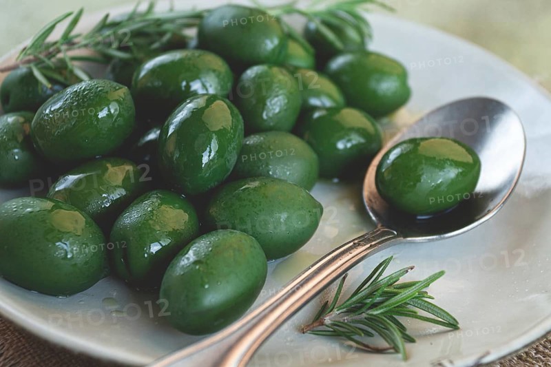 Chalkidiki olives, classic Greek green olive, on a plate, with a spoon, top view, no people
