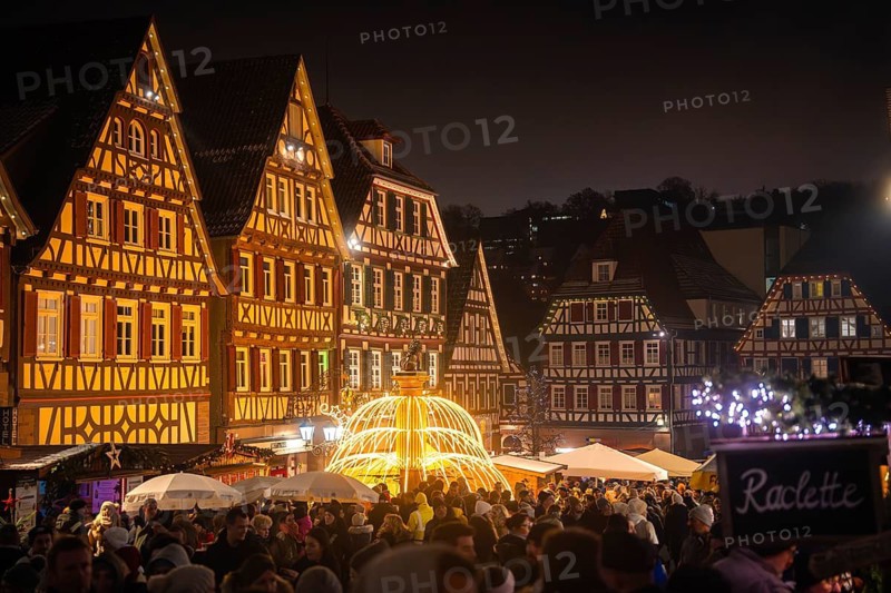 Night shot of a lively Christmas market with shining half-timbered houses and spiral of lights, Christmas market Calw, Black Forest, Germany
