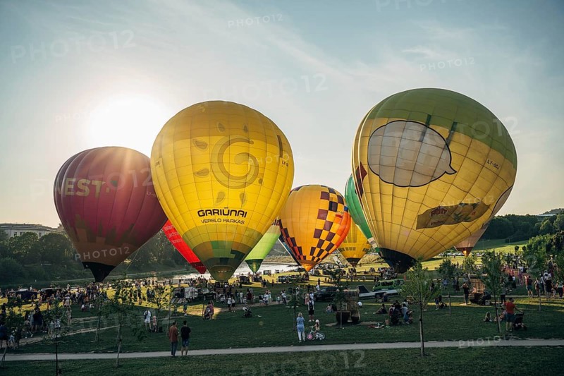 Vilnius, Lithuania, 08 05 2022: Hot air balloons in Vilnius. Multi-colored hot air balloons on the ground before takeoff. Lots of balloons in the field, Hot air balloons of various colors at an outdoor event as the sun sets, creating a lively atmosphere, Vilnius, Lithuania