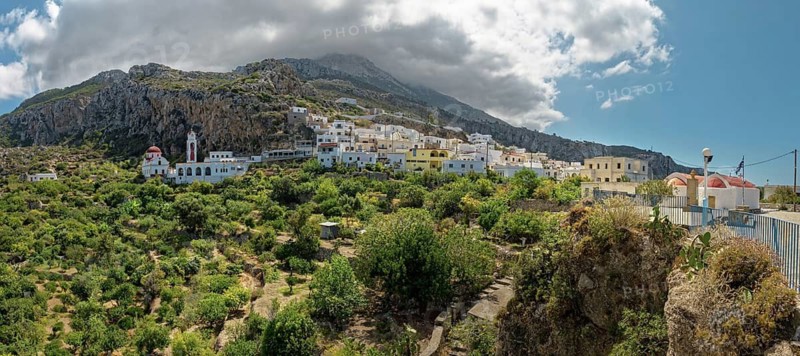 Idyllic village of Mesochori on a mountainside under a dramatic cloudy sky with white architecture, Mesochori, Karpathos, South Aegean, Greece
