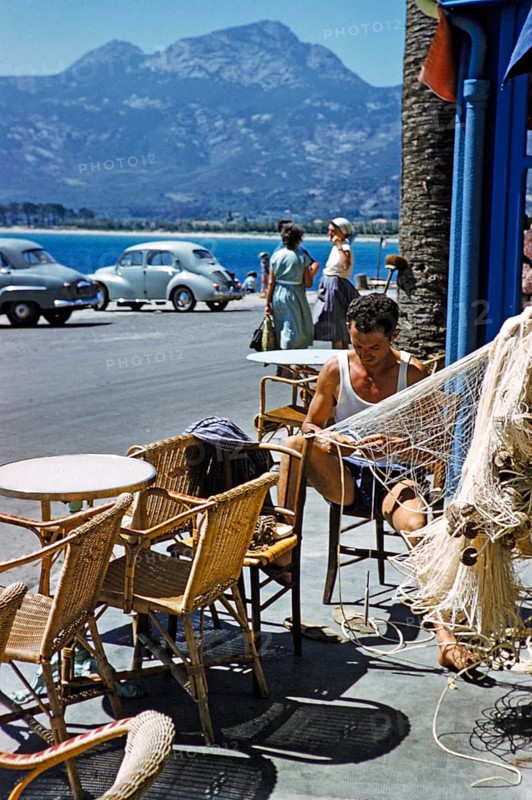 Calvi, Korsika, Frankreich, Ende der 1950er Jahre: Fischer flicken Netze in einem Café am Meer
