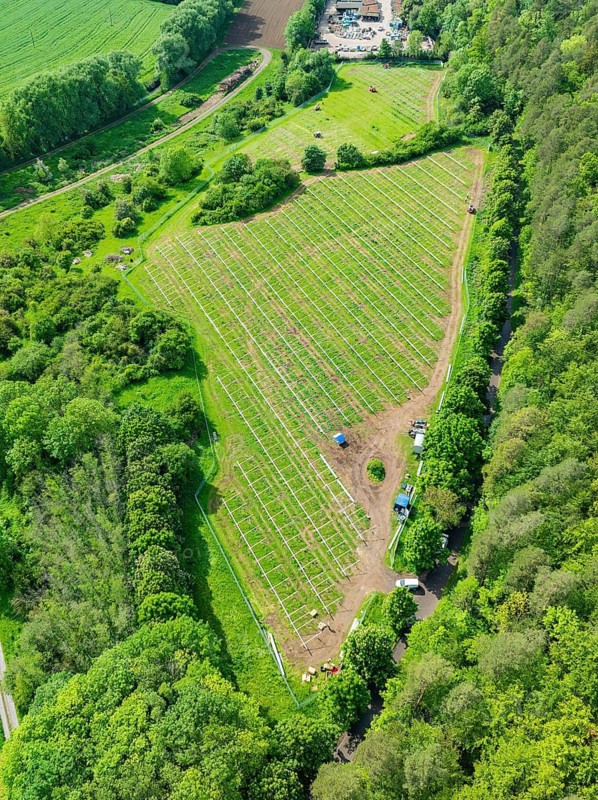 Aerial view of a solar park under construction, surrounded by green fields and forests in the rural landscape, construction of the Black Forest Nature solar park, Weil der Stadt, Germany