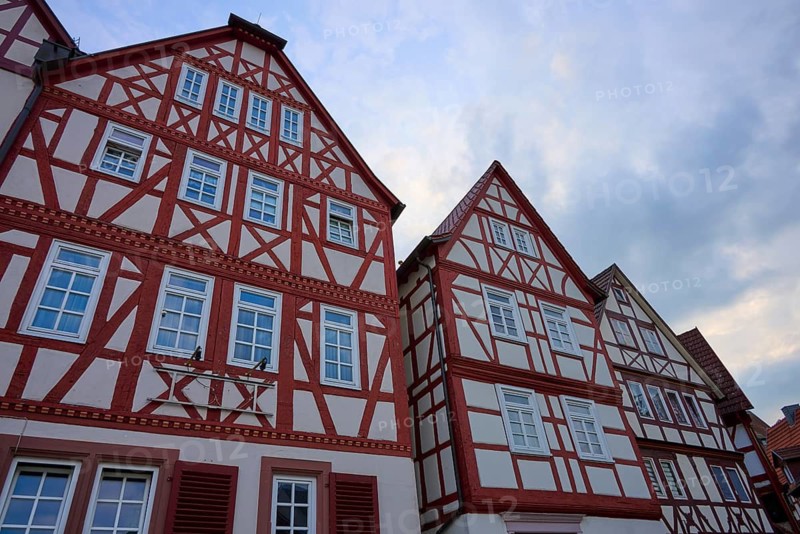 Three half-timbered houses with distinctive red wood and traditional construction, spa town of Bad Orb, Spessart nature park Park, Main Kinzig district, Hesse, Germany