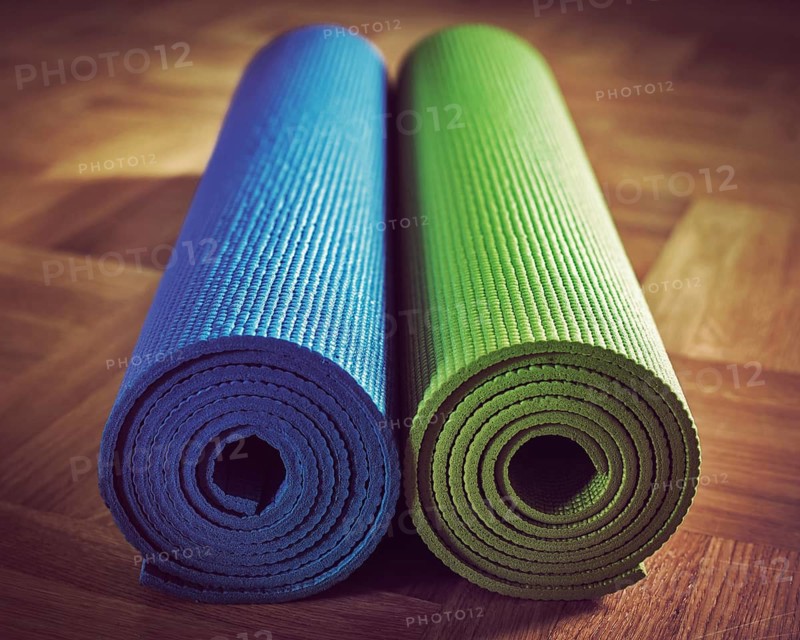 Vintage retro effect filtered hipster style image of Yoga mats on wooden floor