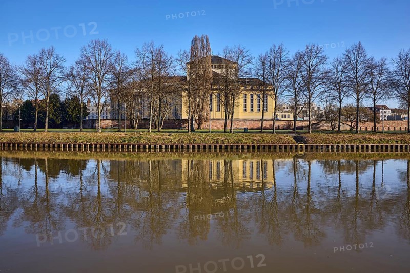 Saarländisches Staatstheater, Saar river, theatre, bank, trees, meadow, symmetrical reflections, water surface, blue sky, cloudless, Saarbrücken, state capital, regional association Saarbrücken, Saarland, Germany