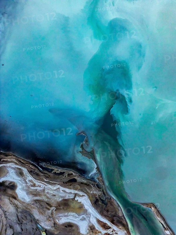 Aerial view of a vibrant geothermal landscape near Rotorua, New Zealand, showcasing dynamic shades of blue and earthy tones, capturing the essence of volcanic activity