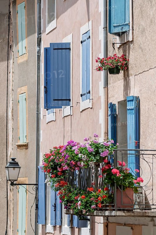 Charming old town façade with blue shutters and blooming flower boxes, Saturnin d'Apt, Provence, France