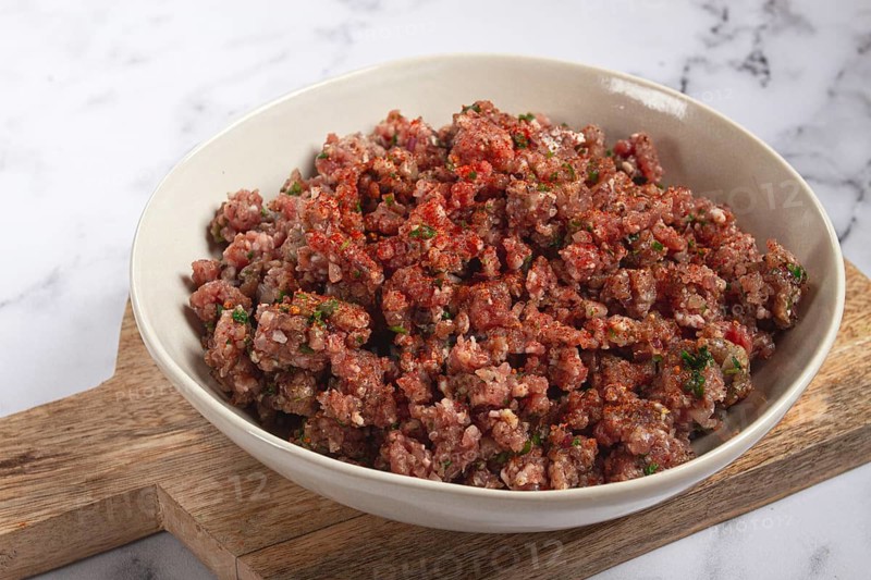 Raw minced meat, marinated with spices and herbs, in a bowl, minced meat with spices, top view, homemade, no people