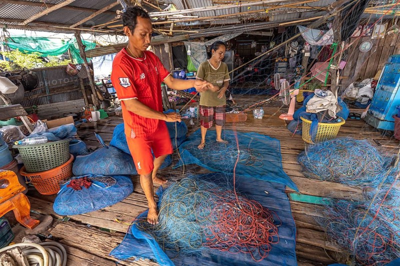 Fishermen repairing their nets, Ban Ao Salad fishing village, Ko Kut island or Koh Kood island in the Gulf of Thailand