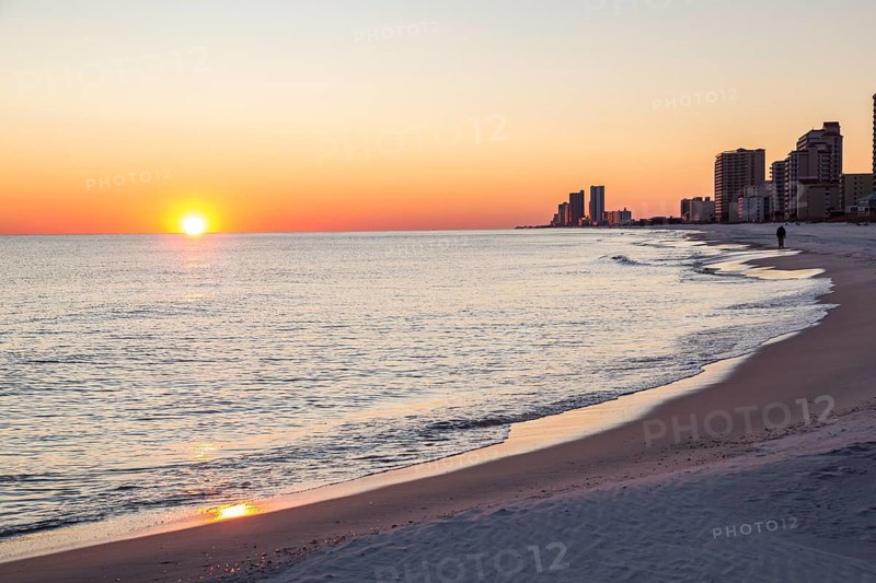 Man walking on the beach at sunset in Gulf Shores, Alabama