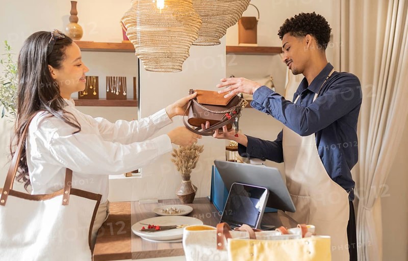 A customer and shop assistant exchanging a handbag in a boutique store. The shop offers a range of stylish and modern bags, creating a welcoming and elegant shopping atmosphere