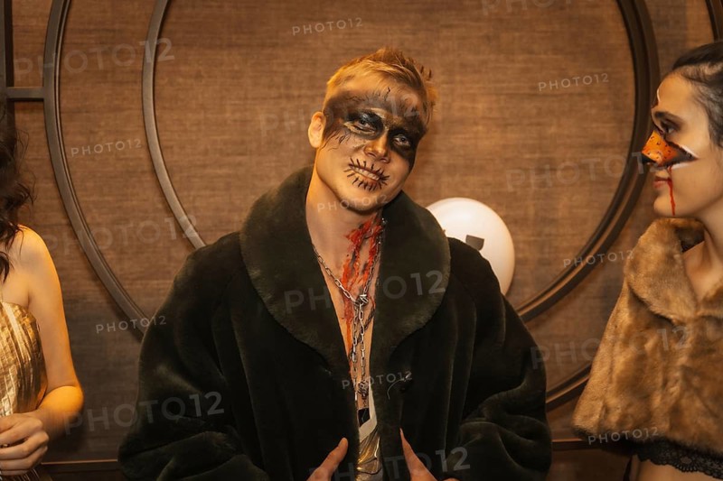 Halloween party with friends in a disco nightclub, portrait of a man in zombie makeup