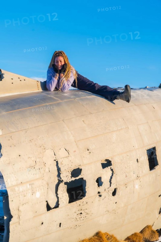 Woman sitting happy on the plane in Solheimasandur smiling on her vacation in Iceland