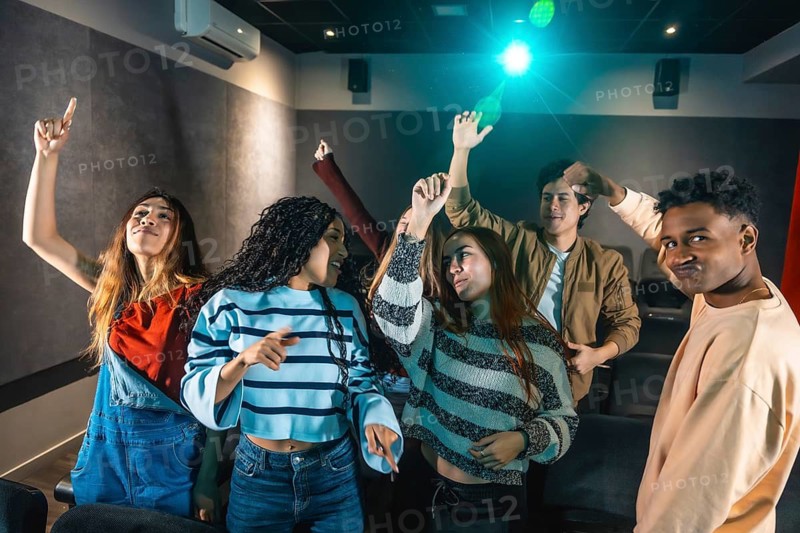Friends dancing and having fun at a movie disco event, enjoying music and togetherness in a unique cinema experience