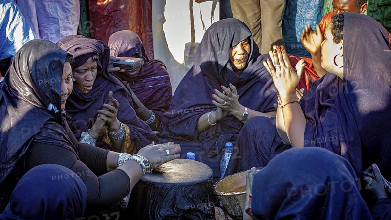 Women in a circle, drumming and praying, emotional and community orientated, Traditional woman playing music at the Tuareg Festival of Tamanrasset in the Sahara in Algeria