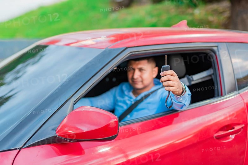 Happy driver showing car key. Male driver showing his car keys