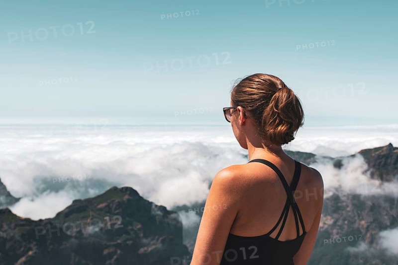 Woman looking from a mountain top over a cloud cover, peaceful atmosphere, Pico Ruivo, Madeira, Portugal