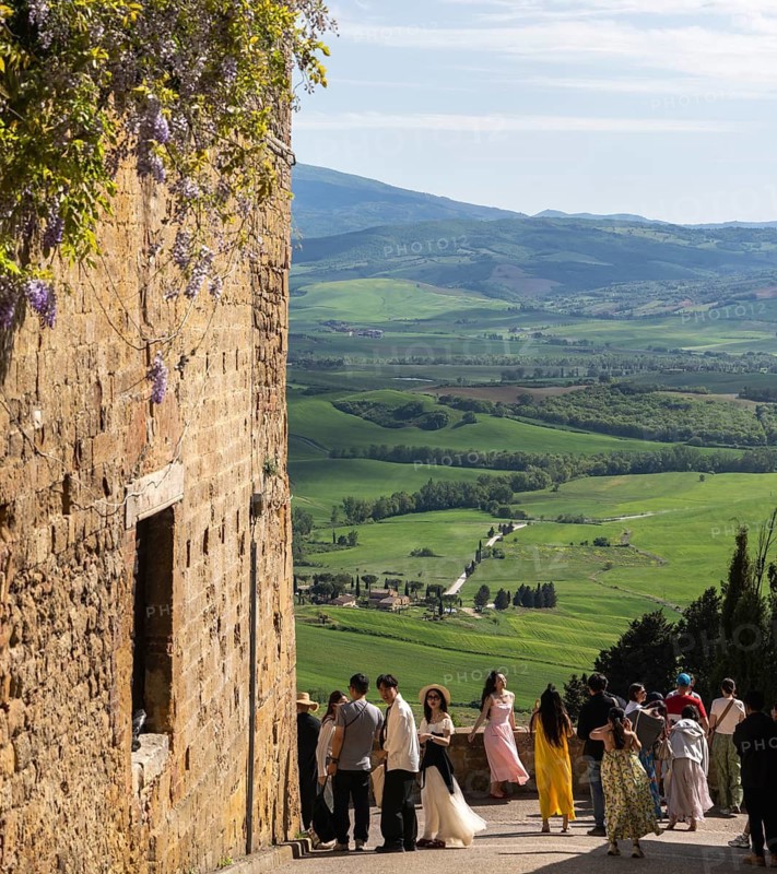 Tourists traveling in the small town of Pienza in Tuscany, Italy