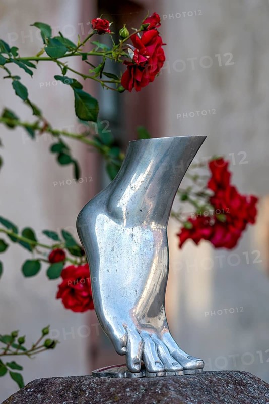 Foot of a woman on tiptoe, silver-coloured sculpture, shiny metallic, red roses in the background, Steinbach, Michelstadt, Odenwald, Hesse, Germany