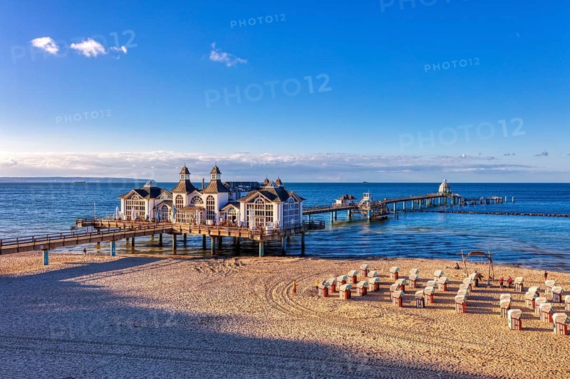 Historic pier with pavilion over the sea and beach chairs on the sandy beach, Rügen, Sellin