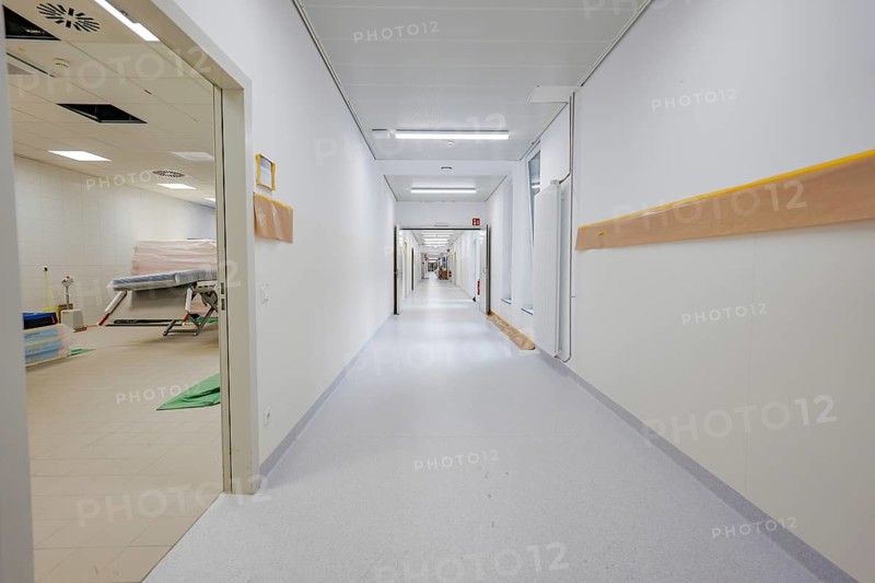 Long, bright corridor in a modern clinic with white walls and yellow handrail, new Calw Hospital, Germany