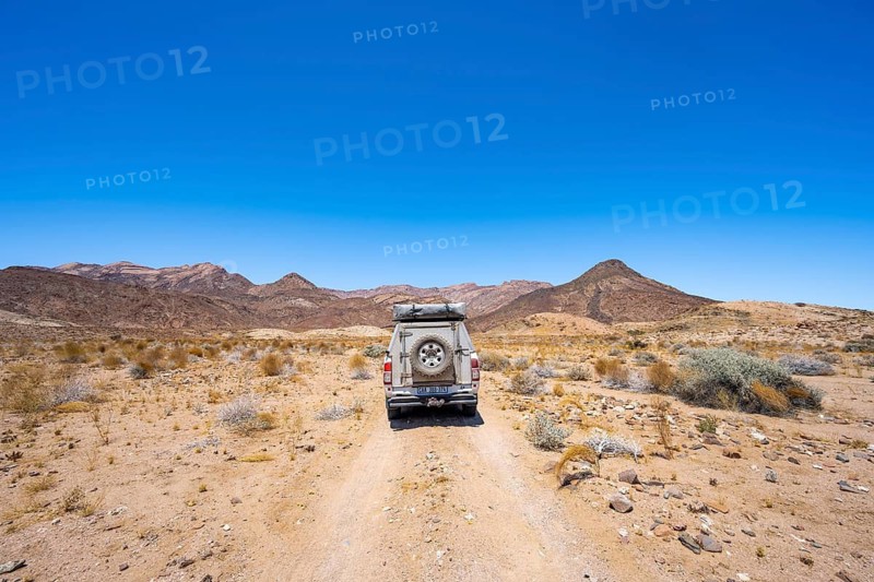 Toyota Hilux off-road vehicle on a sandy track, desert landscape with Brandberg, Erongo, Damaraland, Namibia