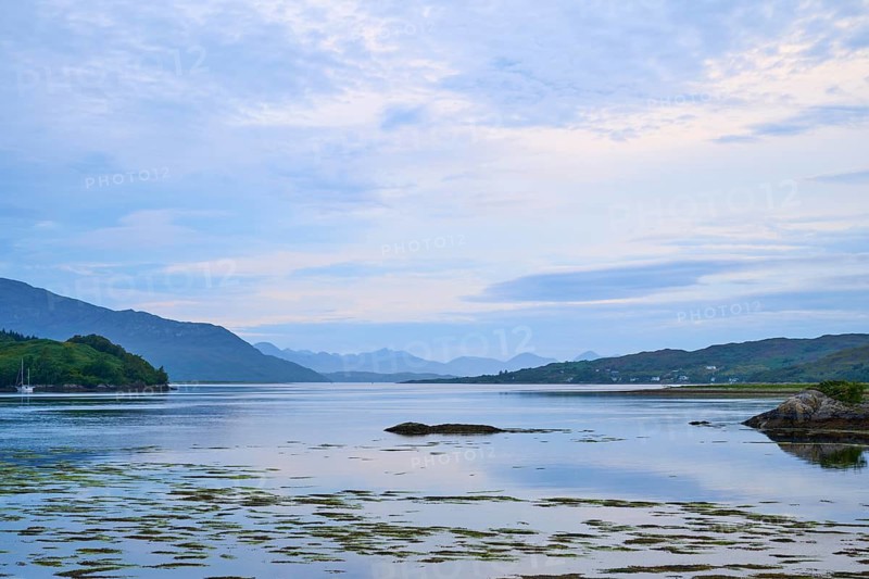 Wide seascape with mountains in the background, framed by a clear blue sky, Dornie, Kyle of Lochalsh, Scotland, United Kingdom, Great Britain