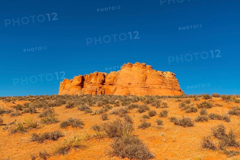 Scenic view of arid page, arizona, capturing the sunlit red rock formation and sprawling desert shrubs, representing wilderness and travel exploration in the american southwest