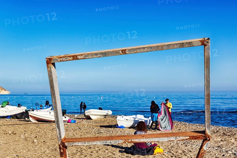 View through wooden scaffolding of walkers and fishing boats, picture frame, Playa de las Negras, coastline, Cabo de Gata-Nijar nature park Park, Las Negras, Nijar, Almeria, Andalusia, Spain